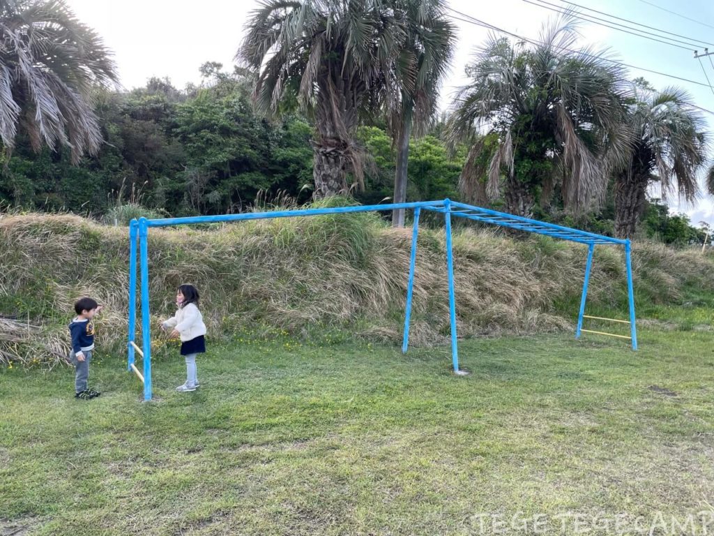 ユクサおおすみ海の学校校庭の雲梯で子供が遊んでいる
